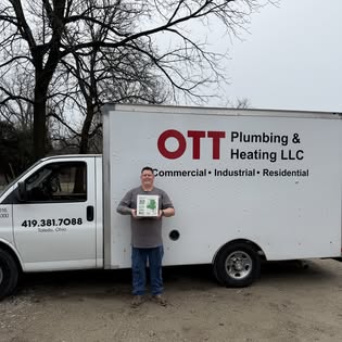 Curt Ott standing in front of an Ott Plumbing and Heating box truck with full company branding and phone number visible.